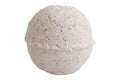 Round bath bomb with speckled texture on a white background